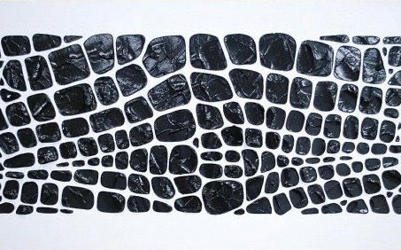 Close-up of black and white mosaic with irregular stone shapes, textured abstract wall art for home decor